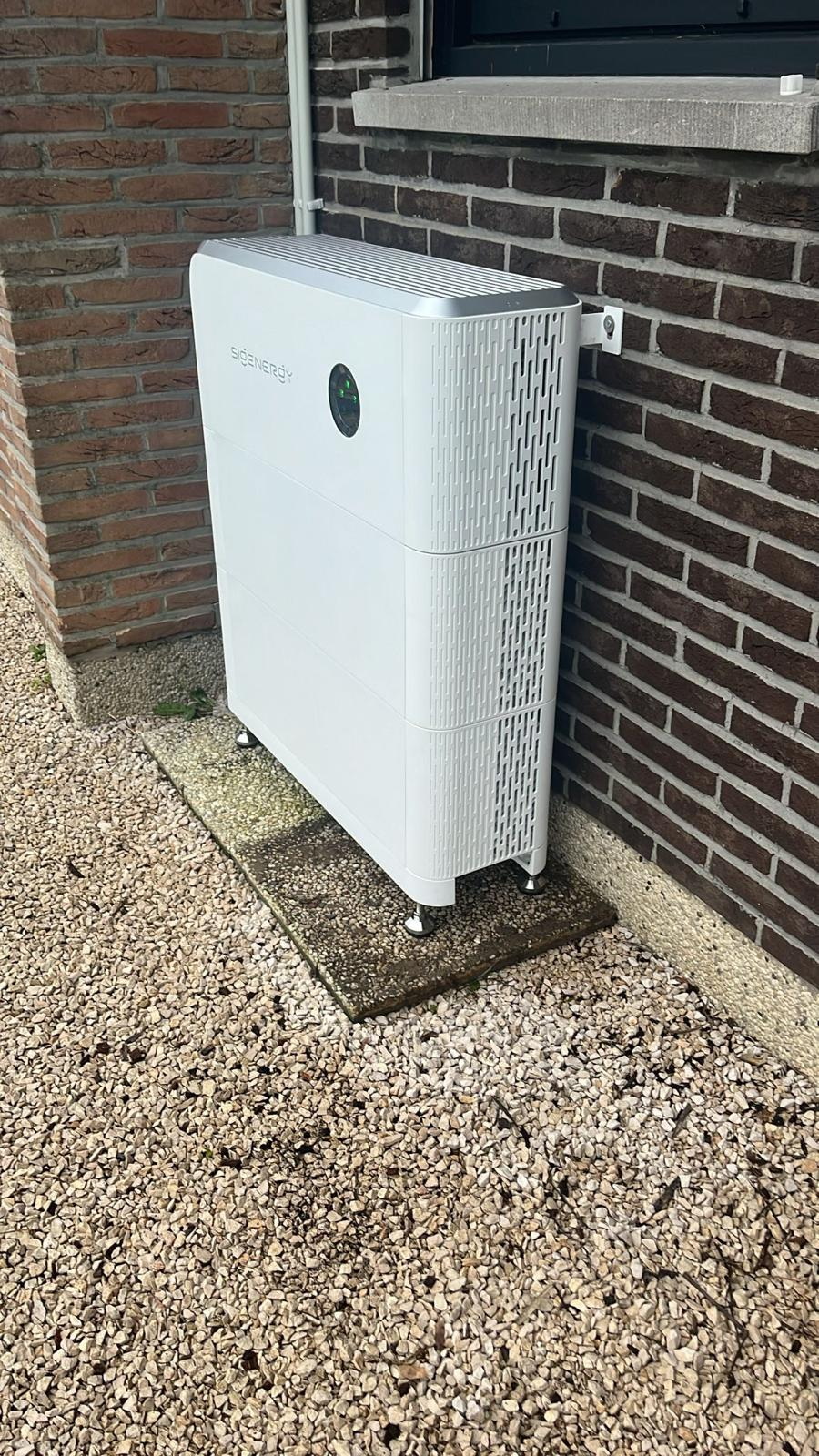 Thuisbatterij buiten tegen een bakstenen gevel